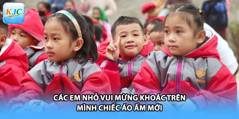 Các em nhỏ vui mừng khoác trên mình chiếc áo ấm mới