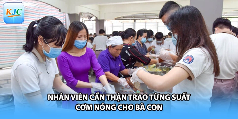 Nhân viên cẩn thận trao từng suất cơm nóng cho bà con